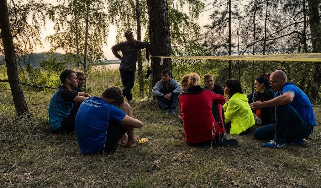 Small group debriefing by the lake